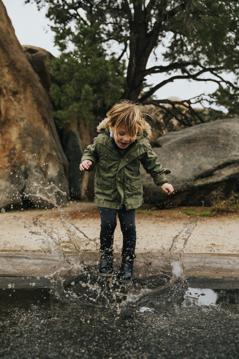 Child splashing puddle in joy
